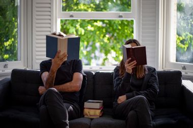 A couple reading books at home