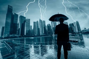 Businessman With Umbrella Looking Storm Over City