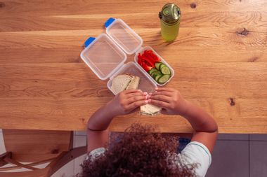 School girl eating healthy lunch during lunch