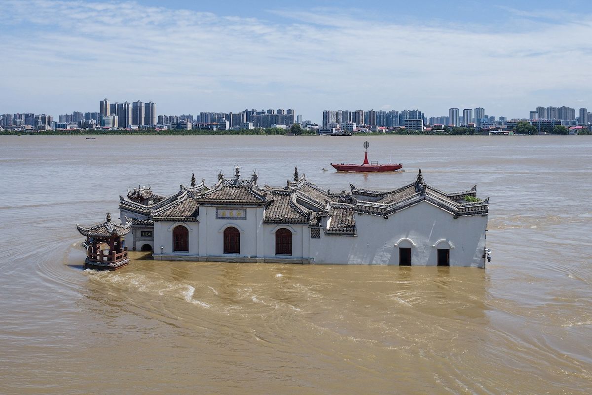 The photo taken on July 6, 2024 shows an aerial view of a partially submerged Guanyin temple in floodwaters in the swollen Yangtze River, in Ezhou, in central China's Hubei province. China is enduring a summer of extreme weather, with flooding across central and southern regions as much of the north swelters through rolling heat waves.  (Photo by AFP / China OUT Photo by STR/AFP via Getty Images)