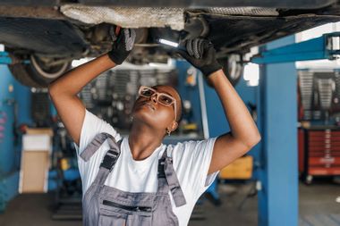 Female auto mechanic working on a vehicle