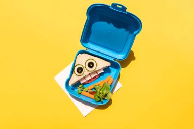 Lunch box with carrot and funny looking sandwich