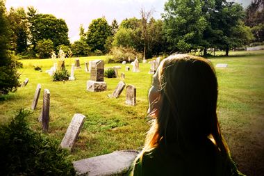 A woman facing a cemetery