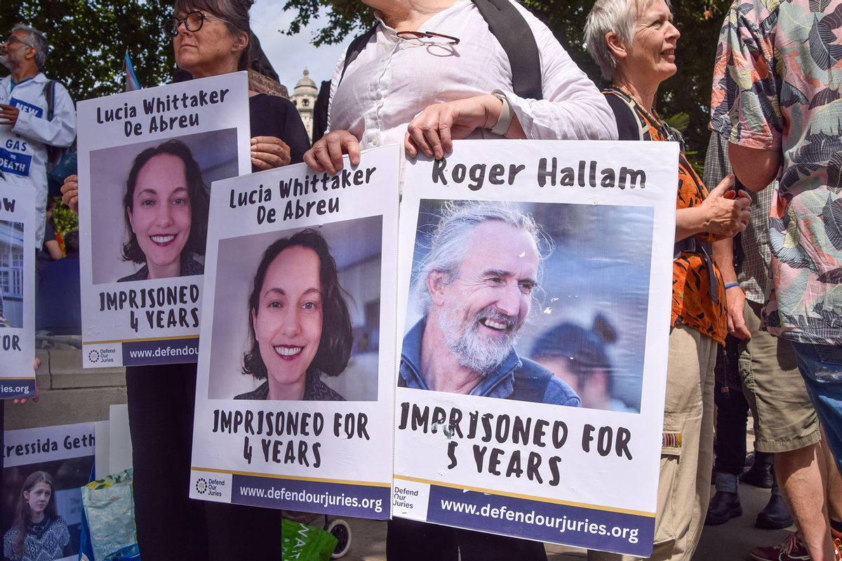 Protesters hold pictures of jailed activists Lucia Whittaker De Abreu and Roger Hallam during the demonstration in Parliament Square. (Vuk Valcic/SOPA Images/LightRocket via Getty Images)