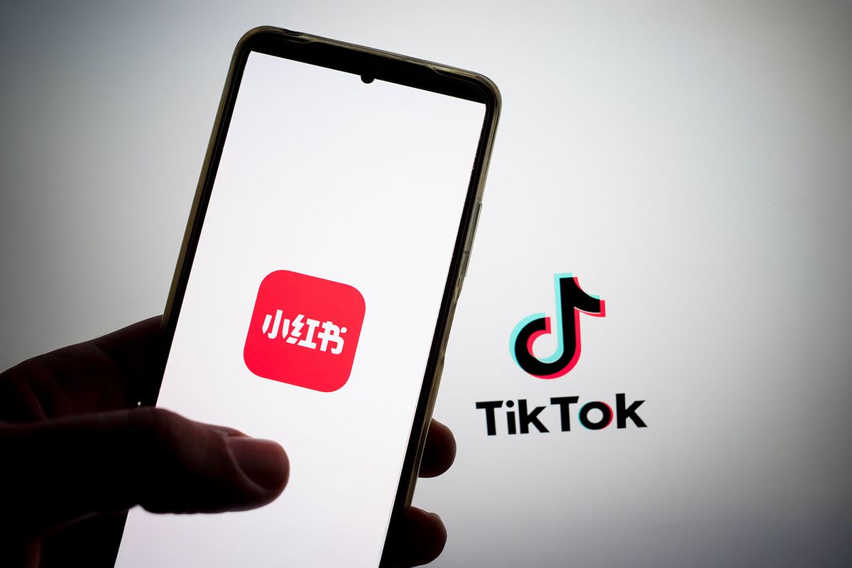 The RedNote logo appears on a smartphone screen, and the TikTok logo appears on a computer screen as the background. (Nikolas Kokovlis/NurPhoto via Getty Images)