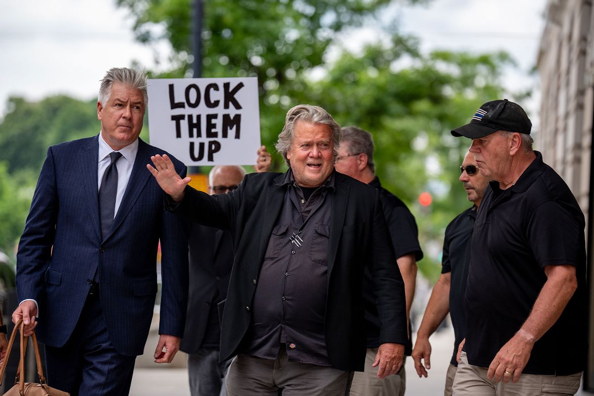 A man holds a sign that reads "Lock Them Up" as Attorney Matthew Evan Corcoran (L) and Steve Bannon, former advisor to President Donald Trump, depart federal court on June 6, 2024 in Washington, DC. (Andrew Harnik/Getty Images)