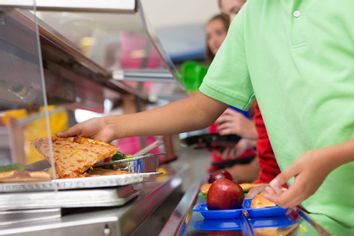 Student taking pizza school lunch line tray