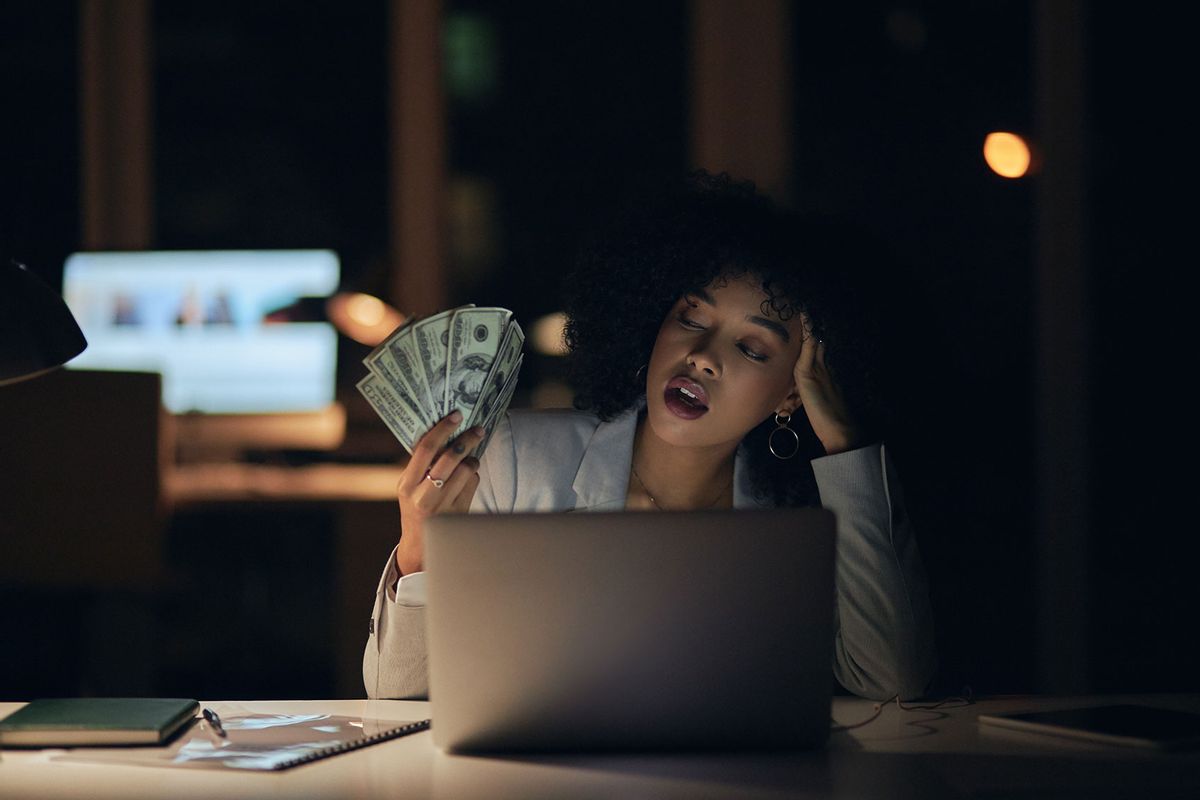 Woman fanning herself with money (Getty Images/Marco VDM)