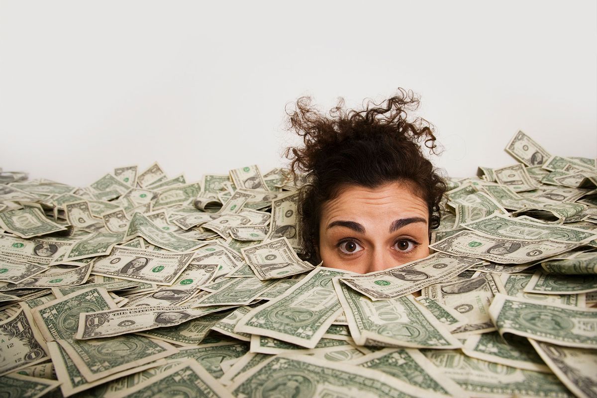 Woman up to her eyes in money (Getty Images/John M Lund Photography Inc)